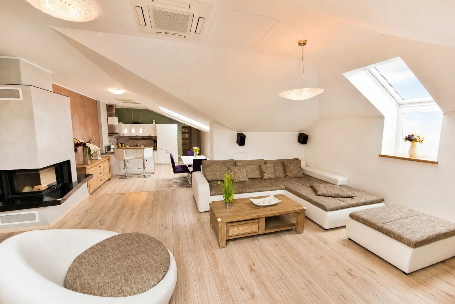 Open-plan living room with fireplace under large roof windows – Cassovia City Park Residence, Košice